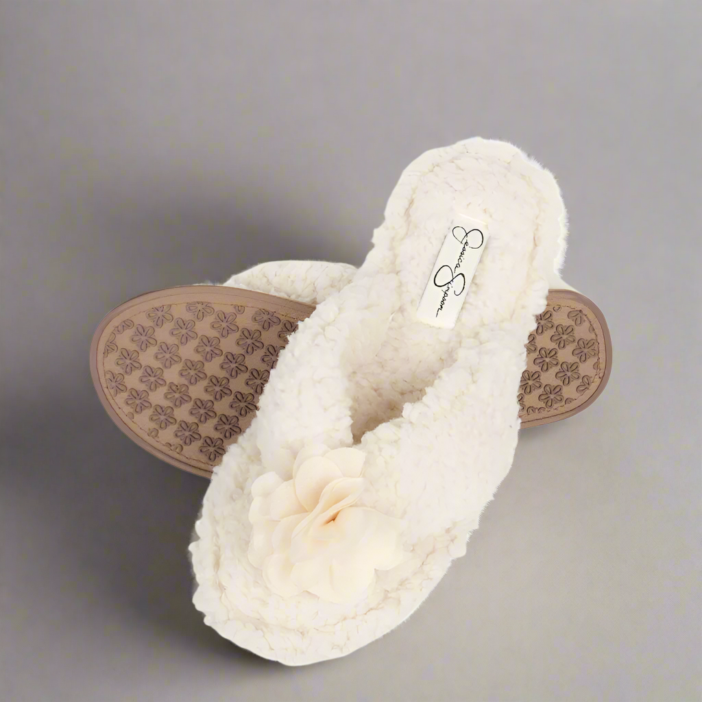 White fuzzy slippers with a patterned sole on a white background