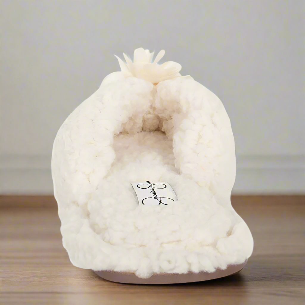 White fluffy slipper with a brand logo on a white background