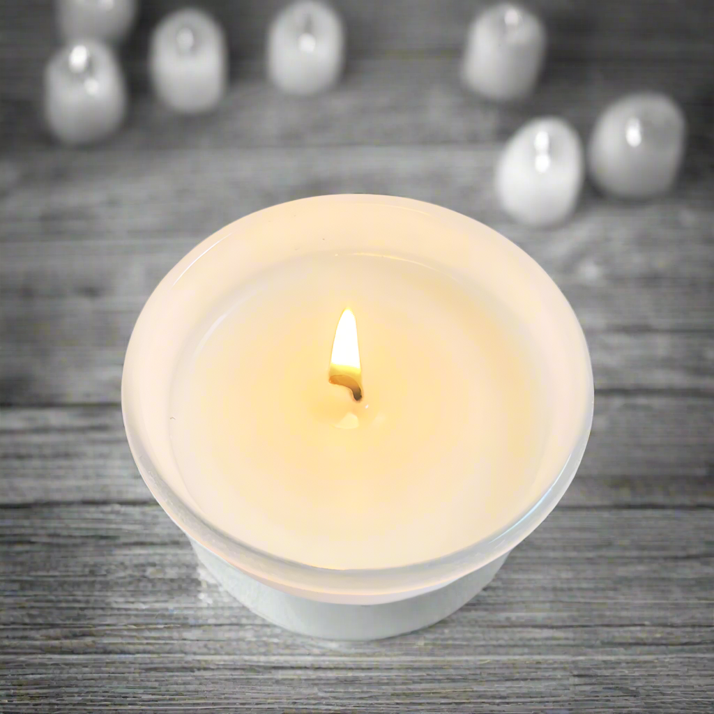 White candle in a glass holder on a white background